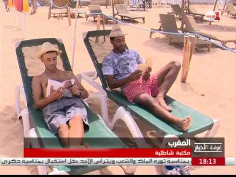 طالب يشارك كتبه الشخصية مع المصطافين على شاطئ الهرهورة