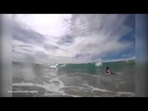 رجل يرصد مرور قرش خلف ابنته